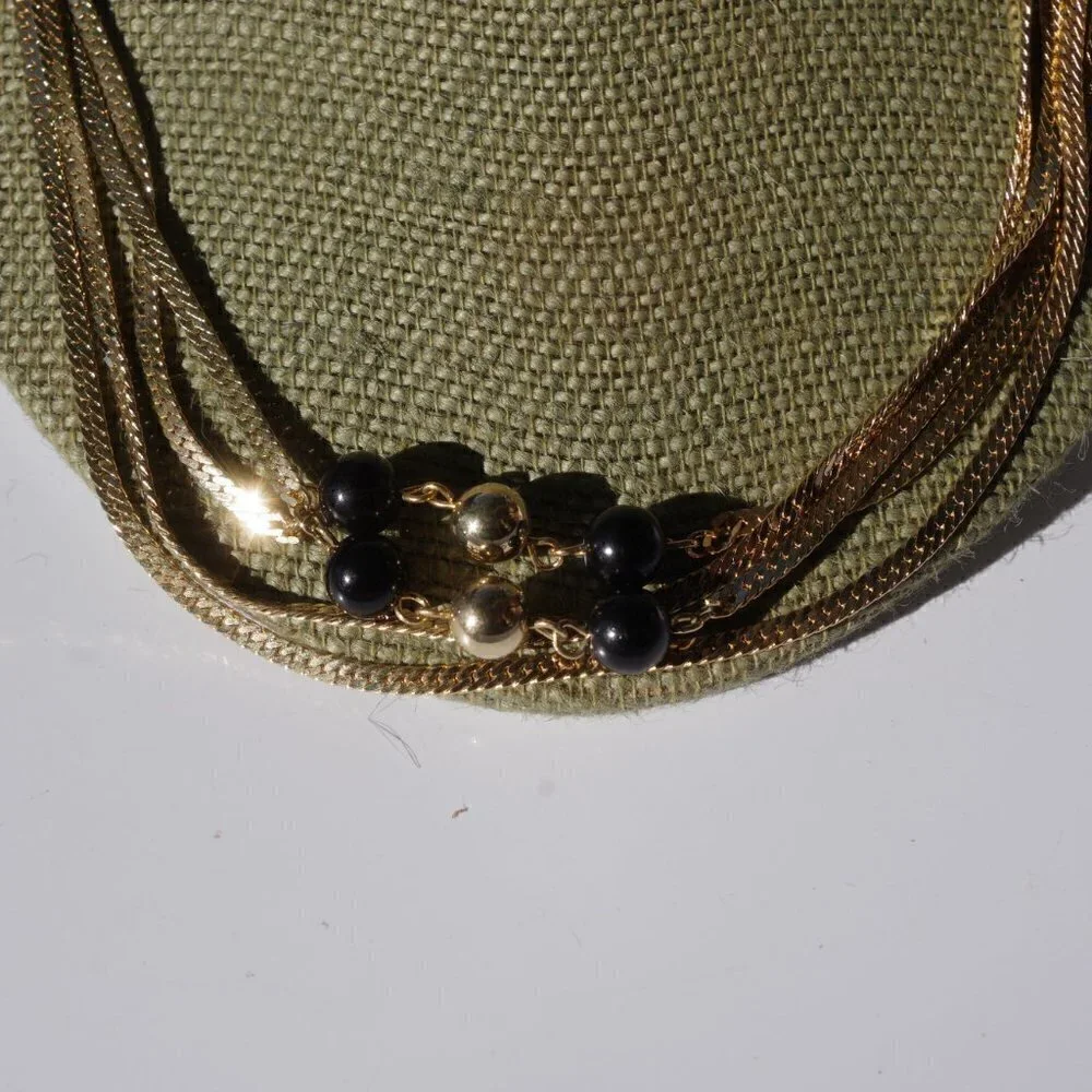 Women`s gold tone black/gold bead chain necklace.
